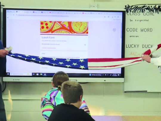 Service organizations present flags to fifth grade students