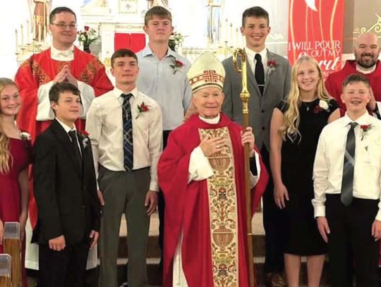 Back row: Fr. Kevin Vogel (left), Gage Krienert (John), Colton (Alberto), Fr. Will Targy; middle row: Michael Vinson (Michael), Klaire Stech (Elizabeth); front row: Kendra (Rose), Crue (Sebastian), Archbishop George Joseph Lucas, Emmett Hoffman (John).
