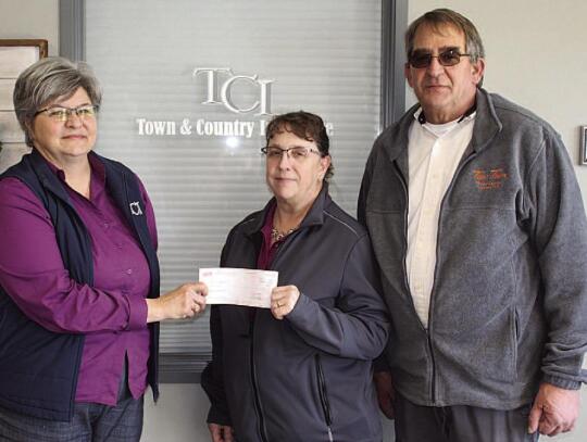 Lisa Schmit of Town &amp; Country (left) presents check to EMTs Missy Hoppe and James Bessmer