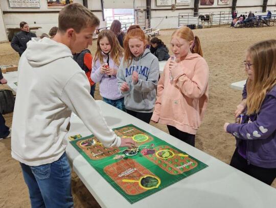 Knox County Ag Facilitator Dylon Nilson, Creighton, talks about his station of the 4-H Ag Innovators Experience – Protect the Plate Challenge to Ari Hoesing, Ally Perry, Brening Kumm and Anna Hansen, fourth-graders at Wausa Public Schools. The station w