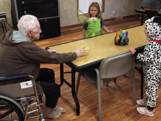 Merlyn Kuhl plays a game with 4-year-olds Mackenzie Gutz and Scarlett Marks.